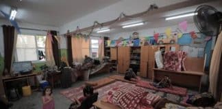 Una famiglia si riunisce in un'aula della New Gaza Boys School dell'UNRWA, nella Striscia di Gaza. Quasi 74.000 sfollati si trovano ora in 64 rifugi dell'UNRWA.