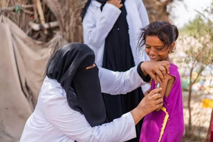 L'operatore sanitario Ghada Ali Obaid, 53 anni, vaccina Aswar Saddiq Othman, 9 anni, durante una campagna di vaccinazione comunitaria per i bambini nel governatorato di Aden, Yemen.