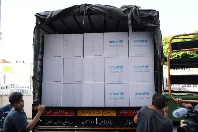 Bottled water and emergency hygiene kits are distributed at a school in Beirut, Lebanon.