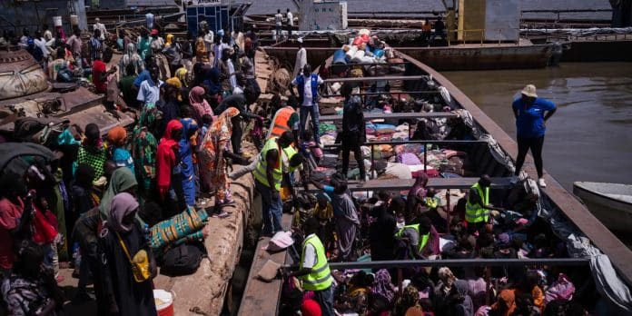 Hjelpearbeidere hjelper hjemvendte fra Sudan i havnen i Renk i Sør-Sudan, der de skal gå om bord i en båt som skal ta rundt 600 passasjerer til Malakal i løpet av to og en halv dag, før de reiser videre til andre deler av landet. Mai 2024. Foto; OCHA/Liz Loh-Taylor