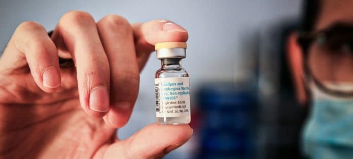 En liten flaska vaccin i en hand